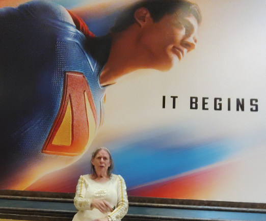 Suzanne in front of a Movie poster of Superman
